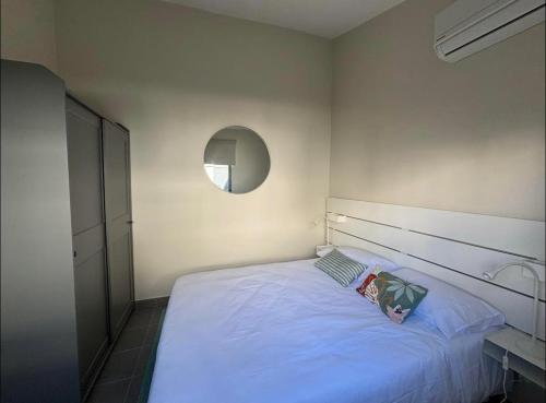 a bedroom with a white bed and a mirror at Casa da Mónica in Ponta Delgada