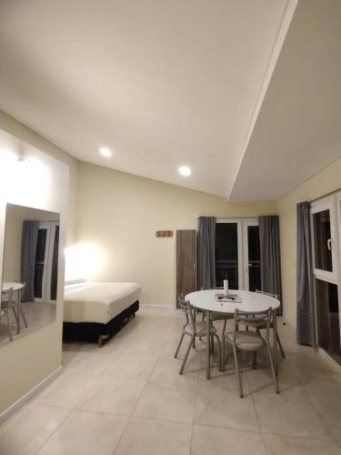 a room with a bed and a table and chairs at La hora azul departamentos in Playas Doradas