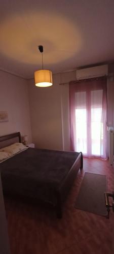a bedroom with a large bed and a window at Rosemary apartment in Eretria