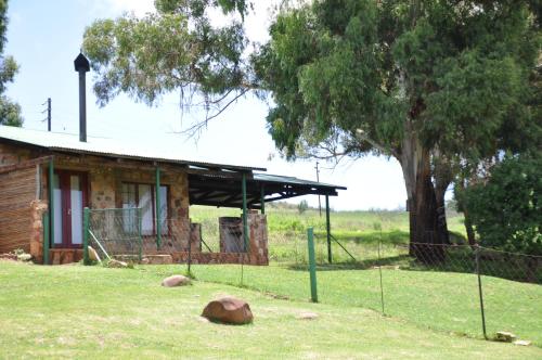 a building with a tree in front of it at Field and Stream in Dullstroom