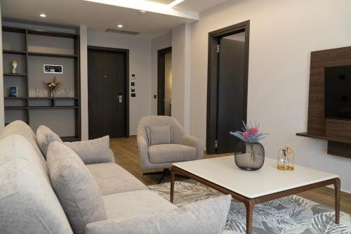 a living room with a couch and a table and chairs at Joelle Premium Hotel in Sarandë