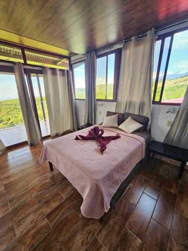 a bedroom with a bed in a room with windows at CreaDora Hotel & Agrotourism Farm in La Estrella