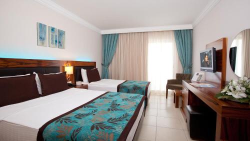 a hotel room with a bed and a desk at Xperia Grand Bali Hotel - All Inclusive in Alanya