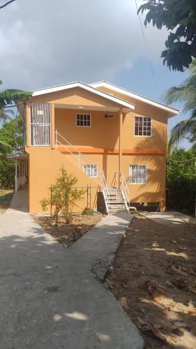 a yellow house with a staircase in front of it at Bellas Place in San Andrés