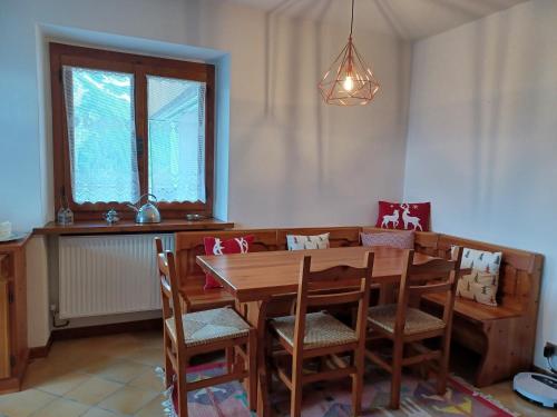 a dining room with a wooden table and chairs at Dafne Dolomites in Cibiana