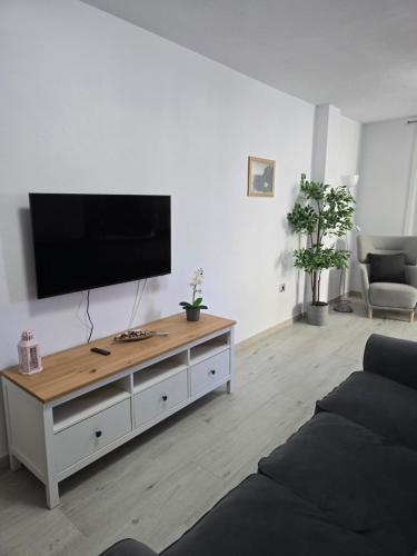 Una sala de estar con un televisor de pantalla plana en una pared. en Balcón de Puerto Naos, en Los Llanos de Aridane