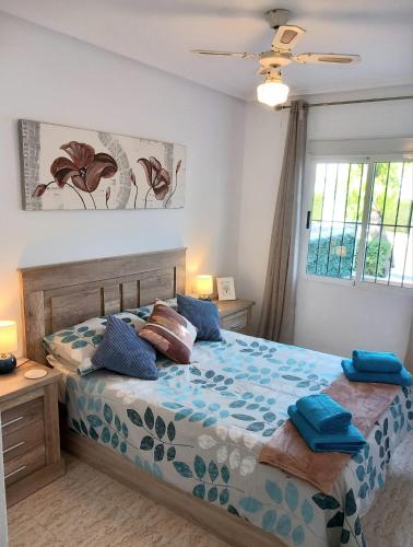 a bedroom with a bed with blue pillows on it at La Florida Apartment Near Emerald Isle Complex in Orihuela Costa