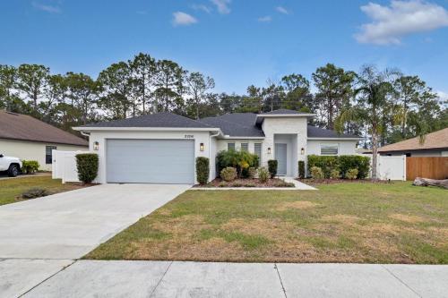a large white house with a garage at Sunny Stay Orlando Queen Room 5 with Shared Bath in Orlando
