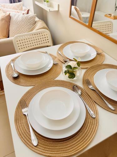 a table with white plates and utensils on it at The ARC Suites in Manila
