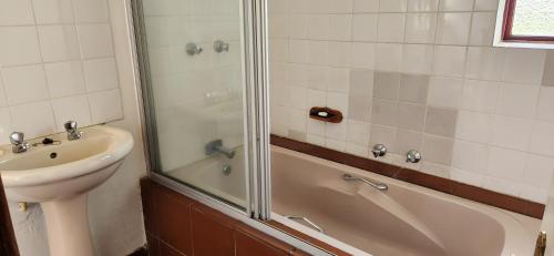 a bathroom with a sink and a tub and a shower at Field and Stream in Dullstroom