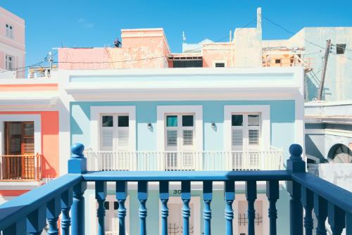 a white house with a blue railing on a balcony at Caribe Rentals in San Juan
