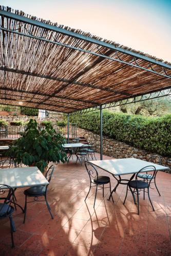 a group of tables and chairs under a wooden pergola at Tenuta Lupinari in Bucine