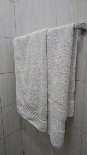 a white towel hanging on a towel rack in a bathroom at Affordable Luxury Ruaka in Ruaka