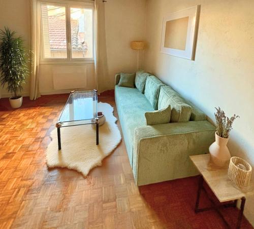 un salon avec un canapé vert et une table dans l'établissement Cocon Avignonnais au Cœur du Centre Historique, à Avignon