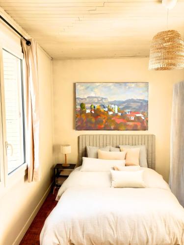 une chambre avec un lit avec un tableau sur le mur dans l'établissement Cocon Avignonnais au Cœur du Centre Historique, à Avignon
