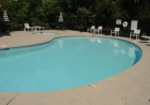 a large blue swimming pool with chairs and tables at Relaxing Condo on the River - NEW Air Hockey Table in Pigeon Forge