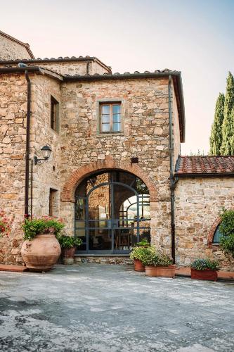a stone building with an archway in a yard at Tenuta Lupinari in Bucine