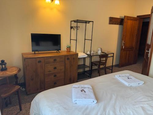 a bedroom with a bed and a television on a dresser at Folwark Nadmorska Ostoja in Mechelinki