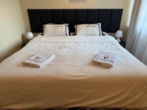 a bedroom with a large bed with two towels on it at Folwark Nadmorska Ostoja in Mechelinki