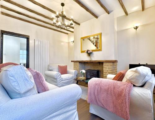 un salon avec deux chaises et une cheminée dans l'établissement Central Buxton - Modern Cottage - Peak District, à Buxton