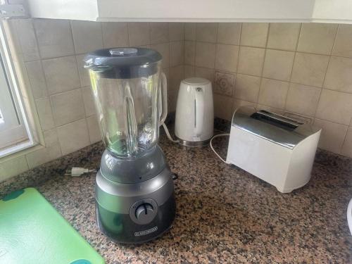 a blender sitting on a counter next to a toaster at Golden Acre Beach Villa-2 mins walk - Alleynes Bay in Saint James