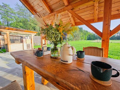 a wooden table with a vase of flowers on it at Zakątek - Żabi Kraj in Mnich