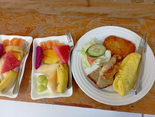 a table with two plates of food with fruit at Langkawi Country Lodge2 in Pantai Cenang