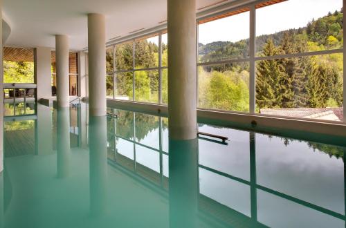 a swimming pool with a view of the water at LA CHENEAUDIÈRE - Hôtel Spa - Relais & Châteaux - Restaurant étoilé in Colroy-la-Roche
