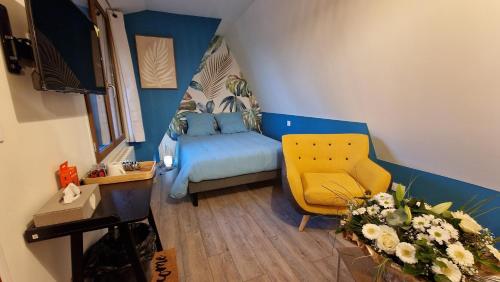 Cette petite chambre comprend un lit et une chaise jaune. dans l'établissement Le Moment d'Evasion, à Beussent