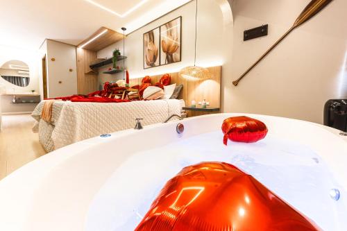 a bath tub in a room with a bedroom at Pousada Natribus Rosa in Praia do Rosa