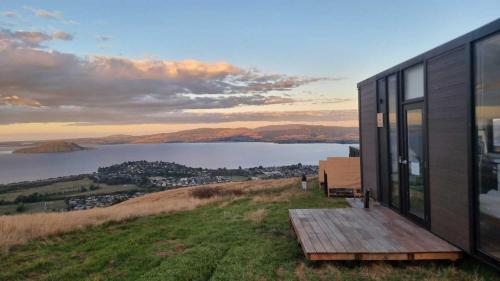 a house on a hill with a view of a lake at Aorangi Peak Cabins 8 by Tiny Away in Rotorua