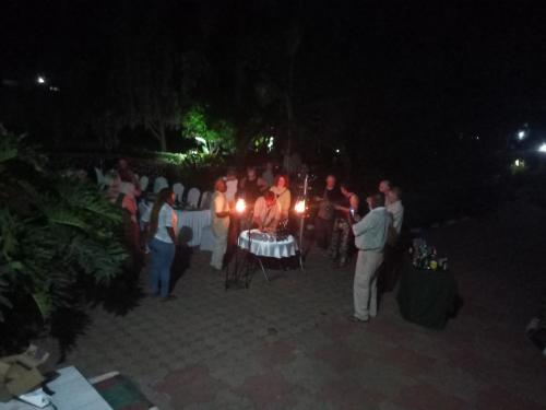 a group of people standing around a table with candles at Africa Lodge Arusha in Nkoaranga