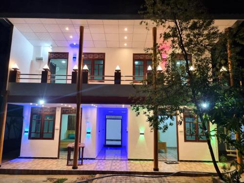 a building with a blue door in the middle at Gowsalya Guest House - Nilaveli Trincomalee in Trincomalee