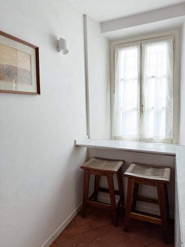 two wooden stools in a room with a window at Villa Sofia in Querceta