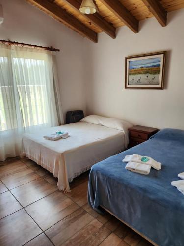 a bedroom with two beds with towels on them at Naturaleza & confort en Tunuyan, Mendoza in Colonia Las Rosas