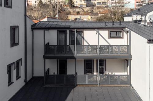 a white house with a balcony on a building at River Apartments in Mladá Boleslav