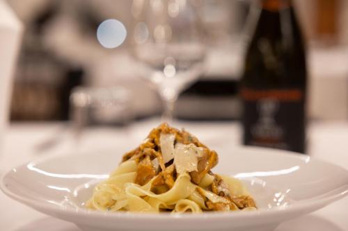 a plate of pasta on a table with a wine glass at Locanda Ca'Vejo srl in Megliadino San Vitale
