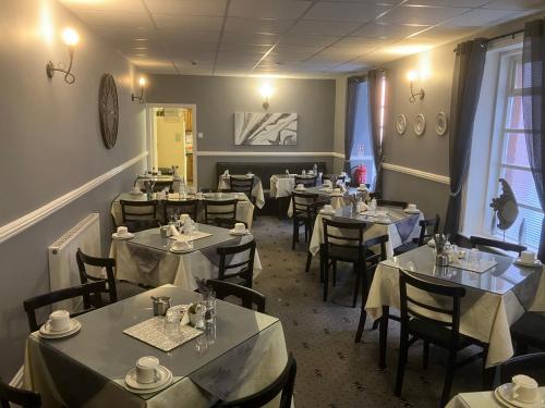 a restaurant with tables and chairs in a room at Pearl Hotel in Blackpool