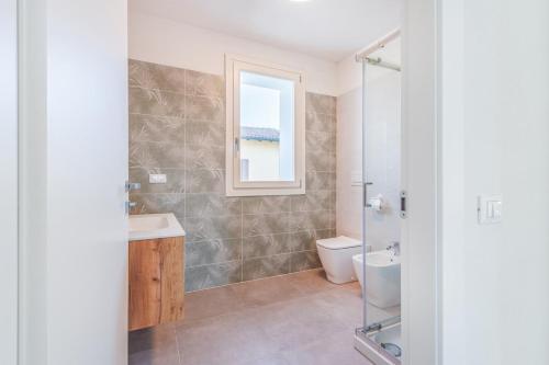 a bathroom with a sink and a toilet and a window at Bellaria Palace - In the hearth of Motor Valley in Modena