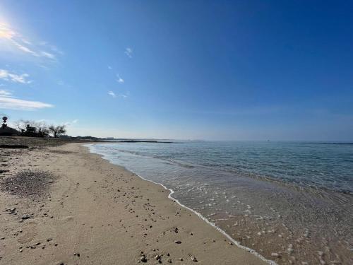 a beach with footprints in the sand and the ocean at Le conchiglie relax in spiaggia in Lido Conchiglie