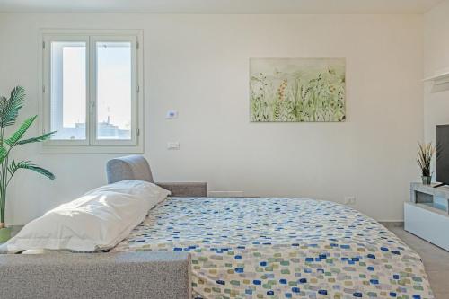 a white bedroom with a bed and a window at Bellaria Palace - In the hearth of Motor Valley in Modena