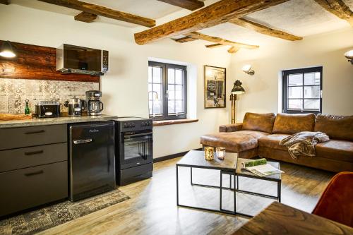 a kitchen and living room with a couch and a table at Vollmer's Hof in Bad Berleburg