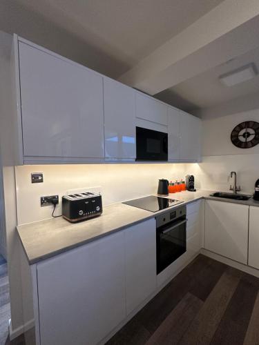 a kitchen with white cabinets and a toaster on a counter at Lake View Apartment Modern,stylish,4 beds, balcony in Bowness-on-Windermere