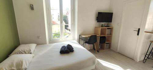 une chambre d'hôtel avec un lit et des chaussures dans l'établissement APPARTEMENT CANNES MONTFLEURY, à Cannes