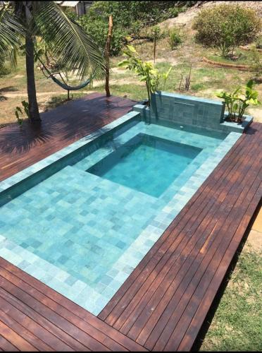 a pool with a wooden deck and a swimming pool at Casa de Madeira Atins 2 bedrooms in Atins