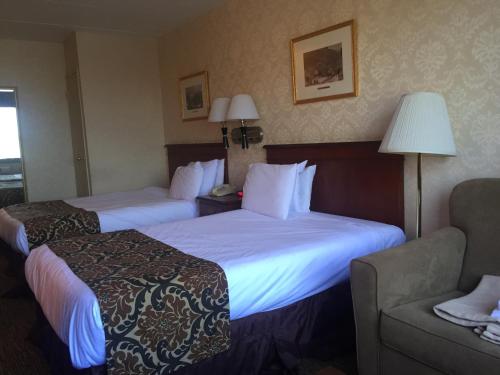 a hotel room with two beds and two lamps at Airway Inn in Queens