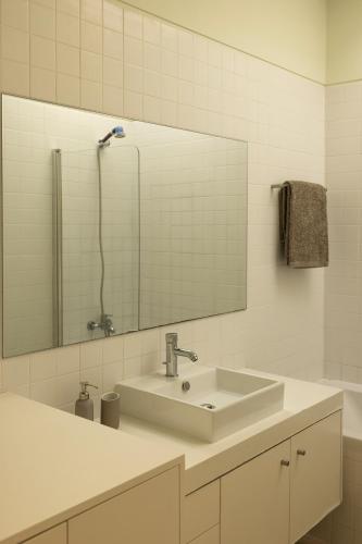 a white bathroom with a sink and a mirror at Bisas Villa in Caminha