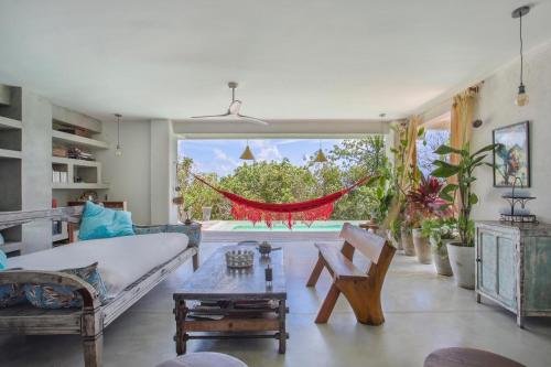 a living room with a couch and a hammock at Casa Dahomey in Pipa