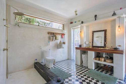 a bathroom with a toilet and a sink and a mirror at Casa Dahomey in Pipa