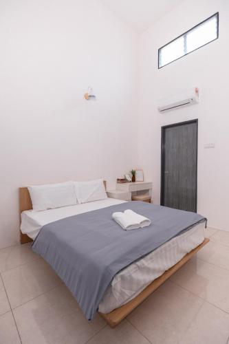 a bedroom with a large bed with a blue blanket at Taiping Bali Home 5R3B, 7mins-Tpg Lake Gardens in Taiping
